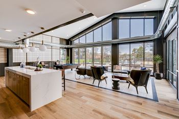 a large open living room with a pool table and a kitchen
